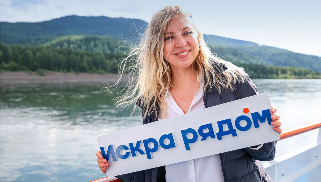 Сотрудница с табличкой в руках ИСКРА РЯДОМ